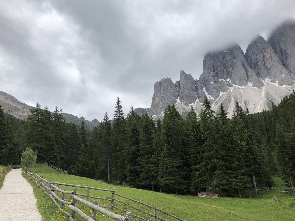 A footpath and rail fence leading toward grey Dolomite peaks