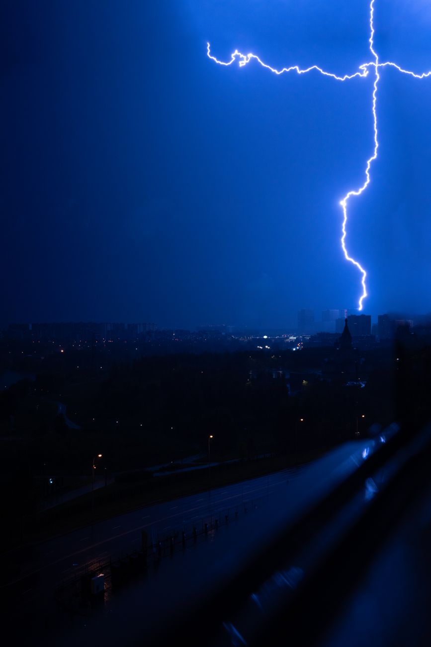 dramatic lightning strike over cityscape at night